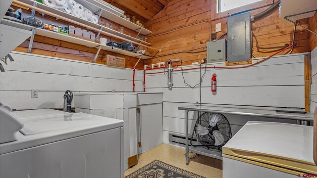 washroom featuring wood walls, washer / dryer, and electric panel