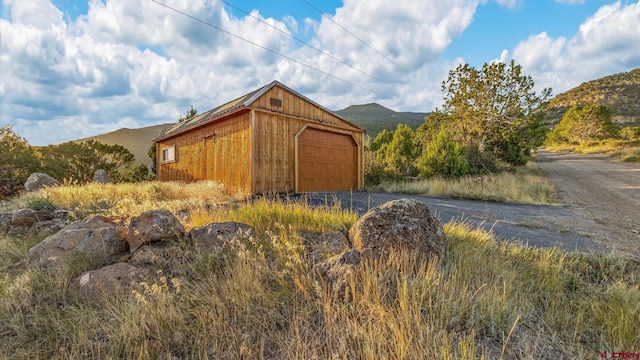 exterior space with a mountain view, an outbuilding, and a garage