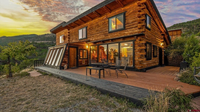 back house at dusk featuring a deck with mountain view