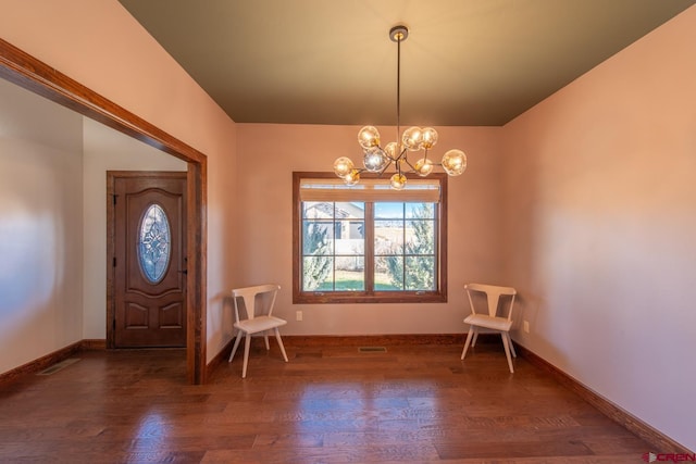 entrance foyer with dark hardwood / wood-style flooring and a chandelier