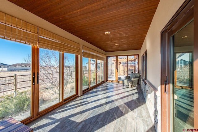 unfurnished sunroom featuring plenty of natural light and wood ceiling