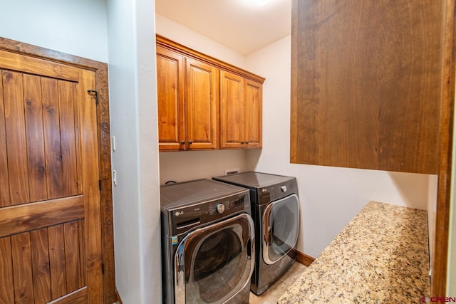 laundry area with washer and clothes dryer and cabinets