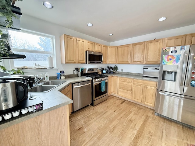 kitchen featuring light brown cabinets, light wood-type flooring, sink, and appliances with stainless steel finishes