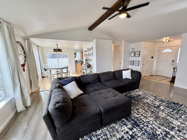 living room with light wood-type flooring, lofted ceiling with beams, and ceiling fan