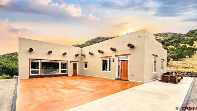 back house at dusk with a patio