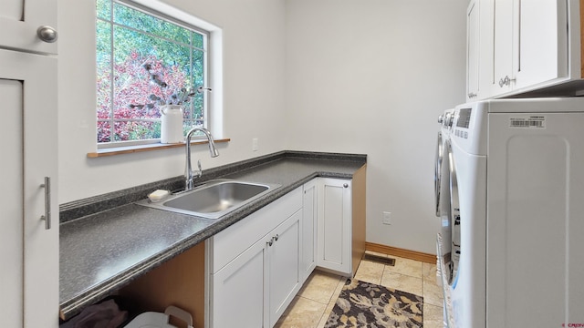 clothes washing area with cabinets, light tile patterned floors, sink, and washing machine and clothes dryer