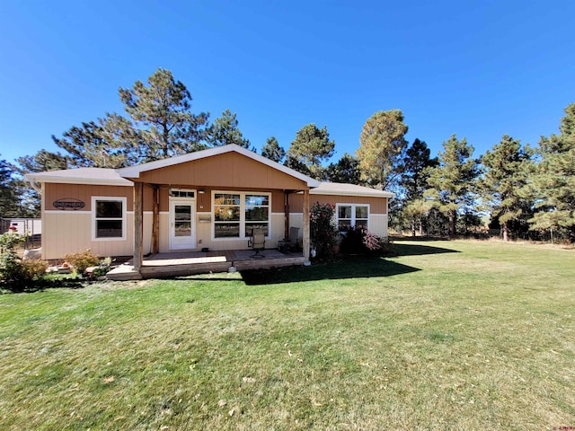 rear view of house featuring a yard