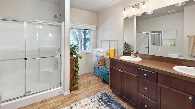 bathroom featuring a shower with door, vanity, and hardwood / wood-style flooring