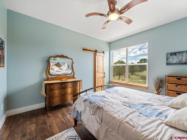 bedroom featuring a barn door, ceiling fan, and dark hardwood / wood-style flooring