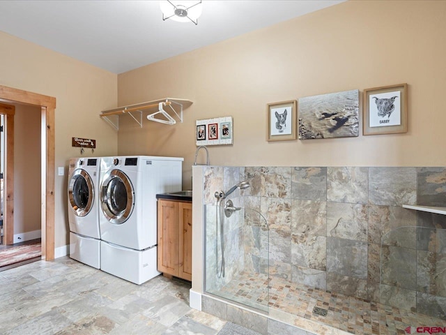 clothes washing area with cabinets and independent washer and dryer