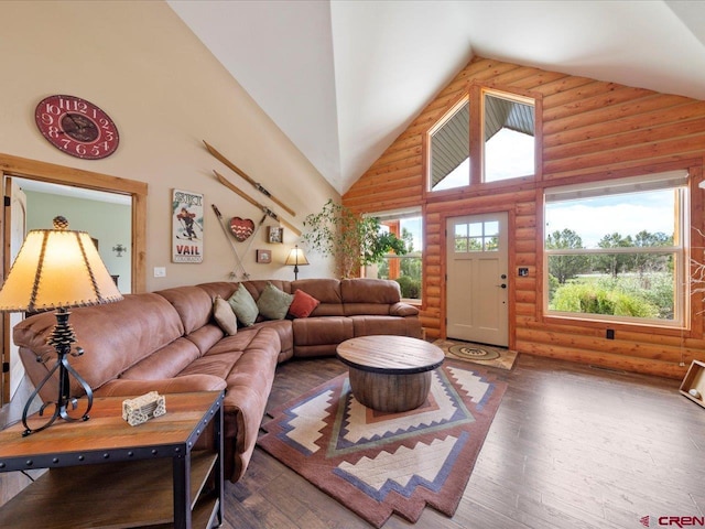 living room featuring log walls, wood-type flooring, and high vaulted ceiling