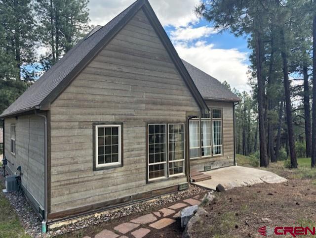 view of side of property with central air condition unit and a patio