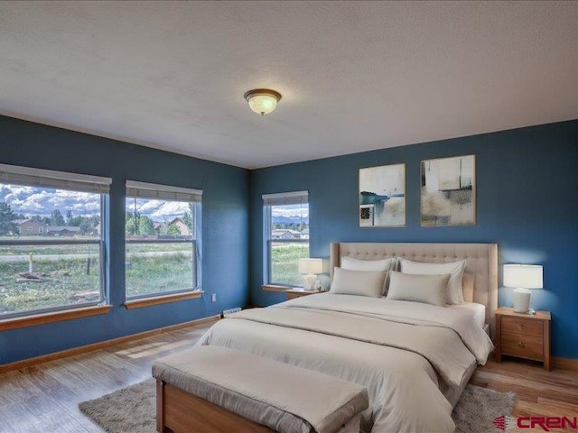 bedroom featuring light wood-type flooring and a textured ceiling