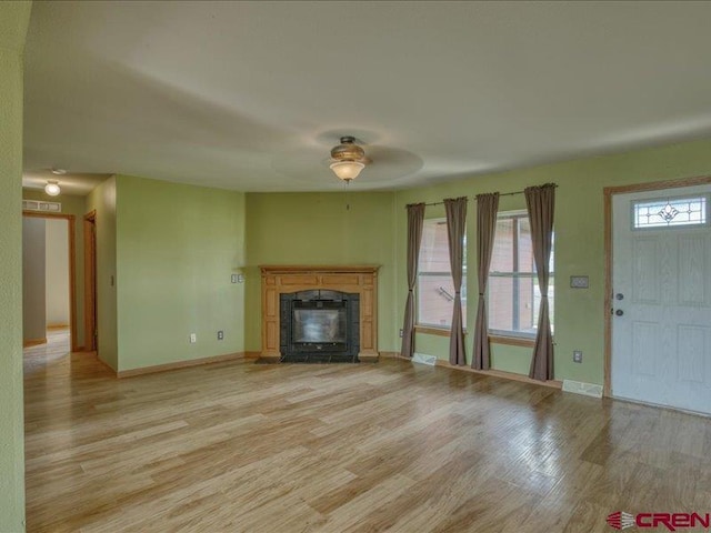 unfurnished living room with ceiling fan and light wood-type flooring