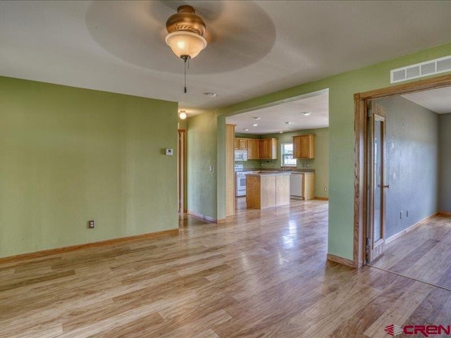 unfurnished living room with ceiling fan and light hardwood / wood-style floors