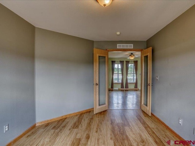 empty room with french doors and light hardwood / wood-style floors