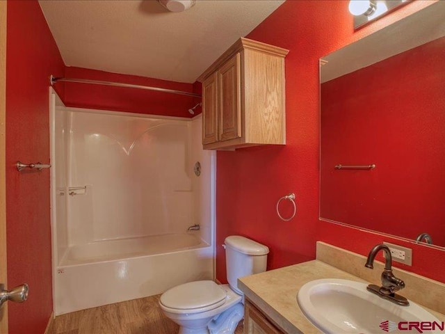 full bathroom featuring hardwood / wood-style floors, vanity, toilet, and bathing tub / shower combination