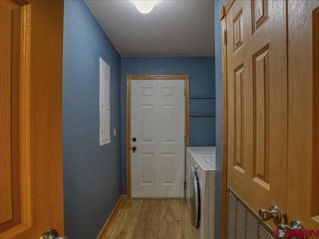 laundry room with light hardwood / wood-style floors, independent washer and dryer, and a textured ceiling