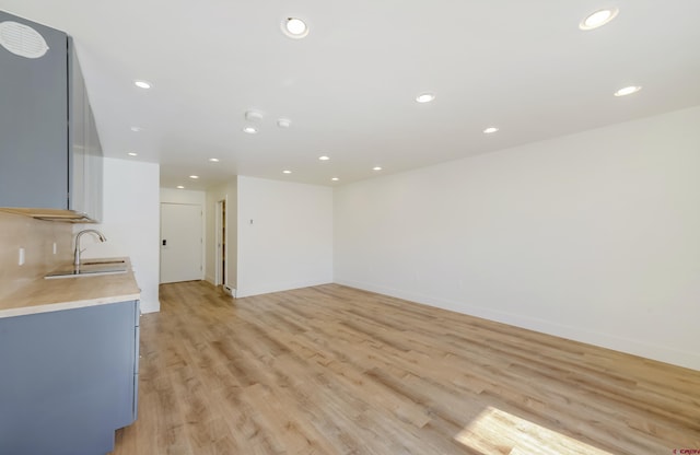 unfurnished living room featuring sink and light wood-type flooring