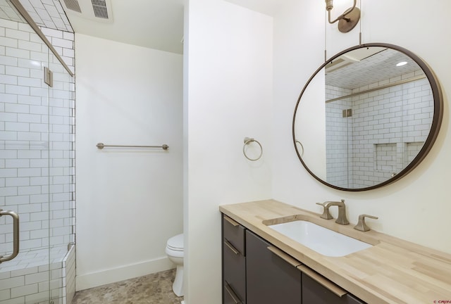 bathroom featuring tile patterned floors, vanity, toilet, and a shower with shower door