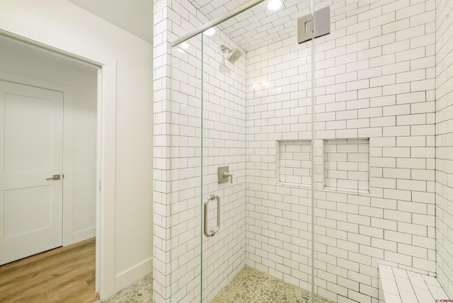 bathroom with hardwood / wood-style floors and an enclosed shower