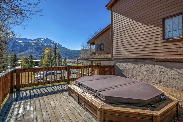 deck featuring a mountain view and a covered hot tub