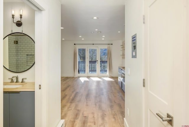 corridor featuring light hardwood / wood-style floors, sink, and french doors