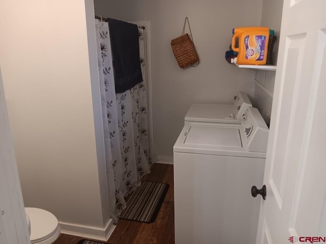 laundry room with laundry area, baseboards, wood finished floors, and washer and dryer