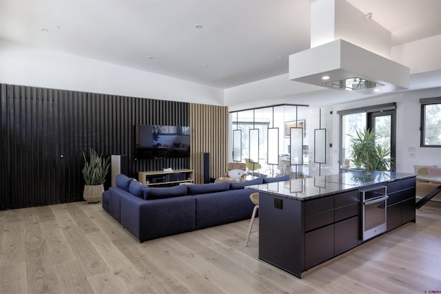 kitchen with island range hood, a spacious island, and light hardwood / wood-style floors