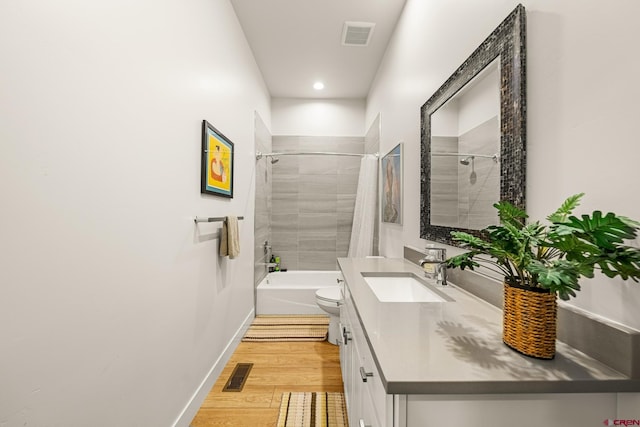 full bathroom featuring shower / tub combo, vanity, hardwood / wood-style flooring, and toilet