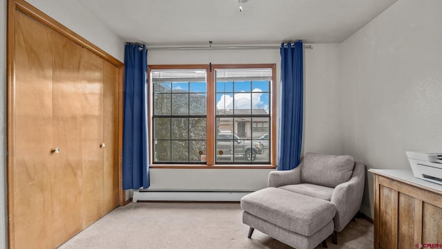 living area featuring light carpet and a baseboard heating unit