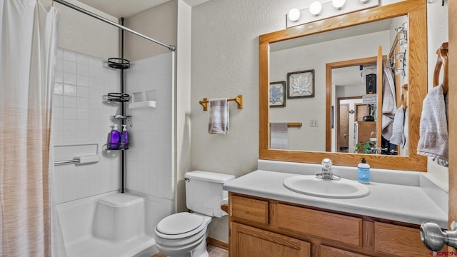 bathroom featuring toilet, vanity, and walk in shower