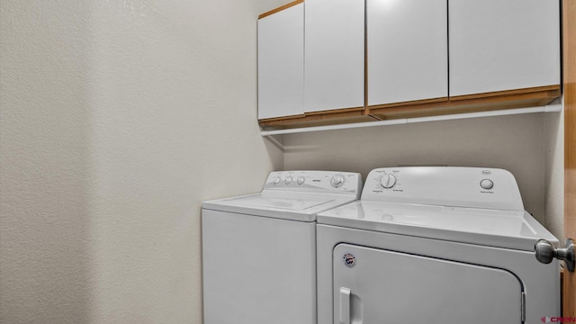 washroom with cabinets and washer and clothes dryer