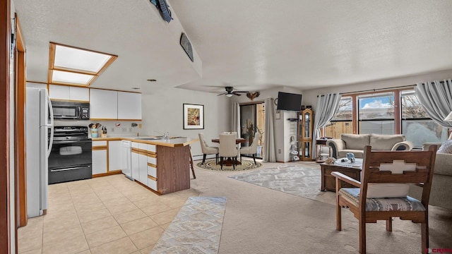 kitchen with black appliances, kitchen peninsula, ceiling fan, a textured ceiling, and white cabinetry