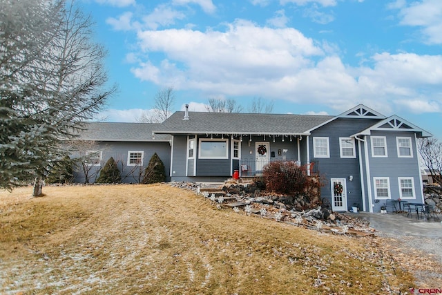 view of front of home featuring covered porch and a front lawn