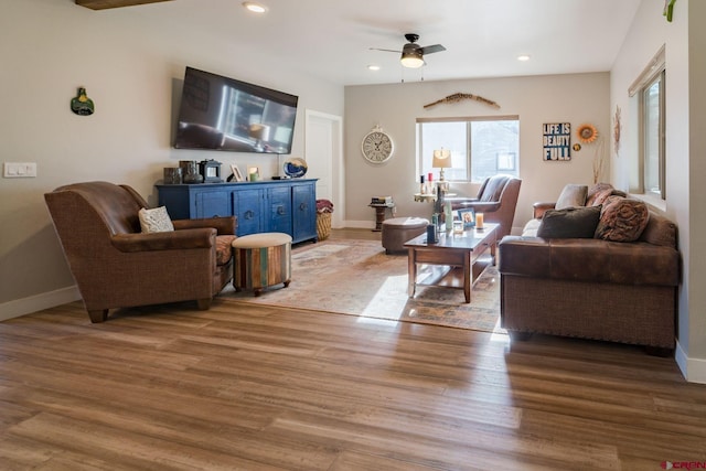 living room with light hardwood / wood-style floors and ceiling fan