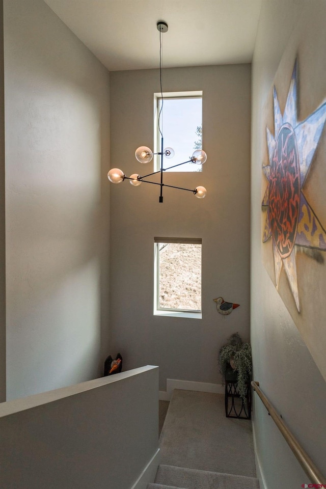 staircase with an inviting chandelier