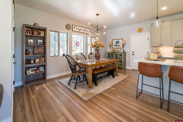 dining area with a chandelier and light hardwood / wood-style flooring