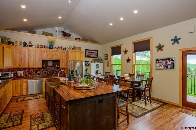 kitchen featuring backsplash, a center island with sink, plenty of natural light, and appliances with stainless steel finishes