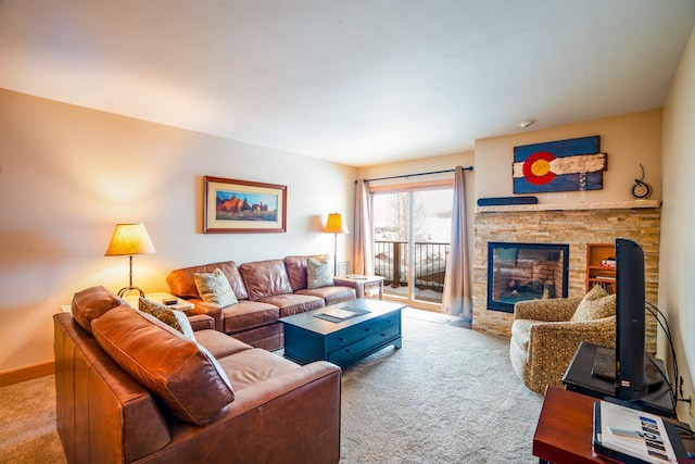 carpeted living room with a stone fireplace