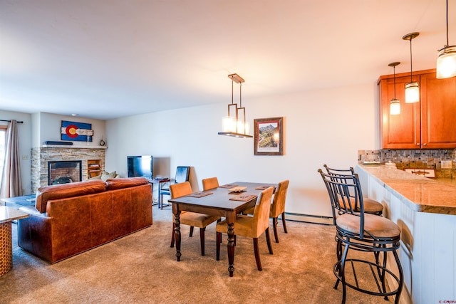 dining space with a fireplace, light carpet, and baseboard heating