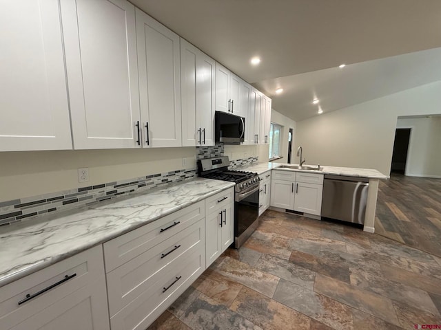 kitchen with white cabinets, stainless steel appliances, sink, kitchen peninsula, and light stone counters