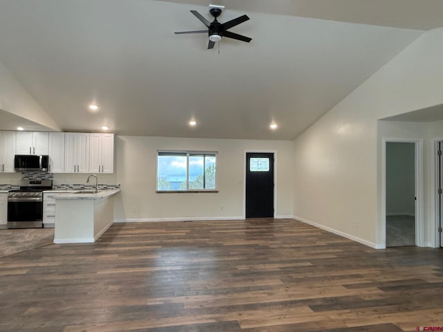 kitchen featuring vaulted ceiling, white cabinetry, kitchen peninsula, dark wood-type flooring, and stainless steel appliances