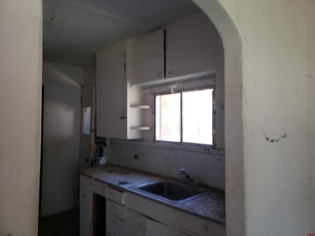 kitchen with white cabinets, backsplash, and sink