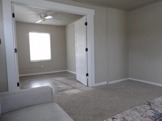 carpeted spare room featuring ceiling fan, a textured ceiling, and ornamental molding