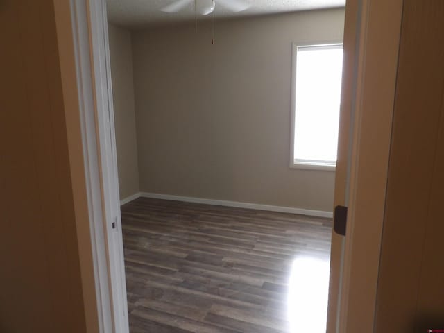 empty room with ceiling fan, dark hardwood / wood-style flooring, and a textured ceiling