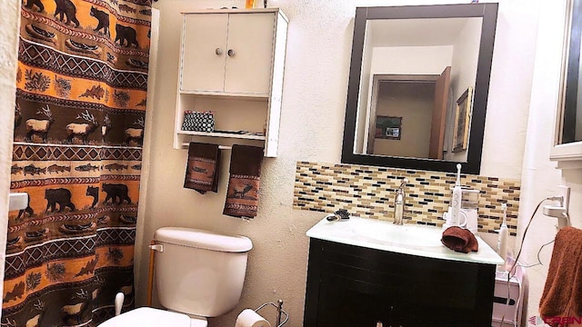 bathroom with vanity, toilet, and backsplash