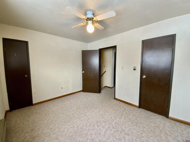 unfurnished bedroom with ceiling fan and light colored carpet