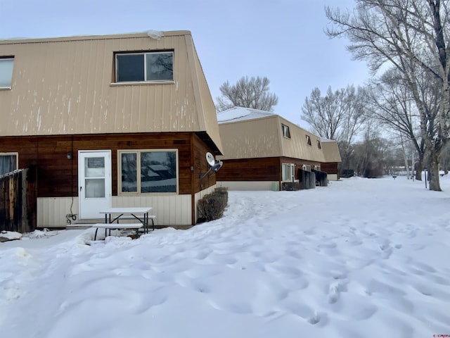 view of snow covered rear of property