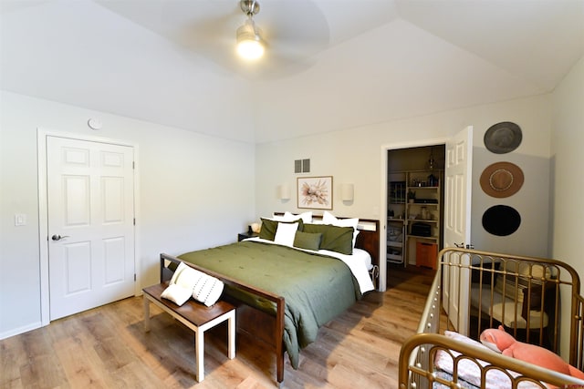 bedroom with a spacious closet, ceiling fan, vaulted ceiling, a closet, and light wood-type flooring